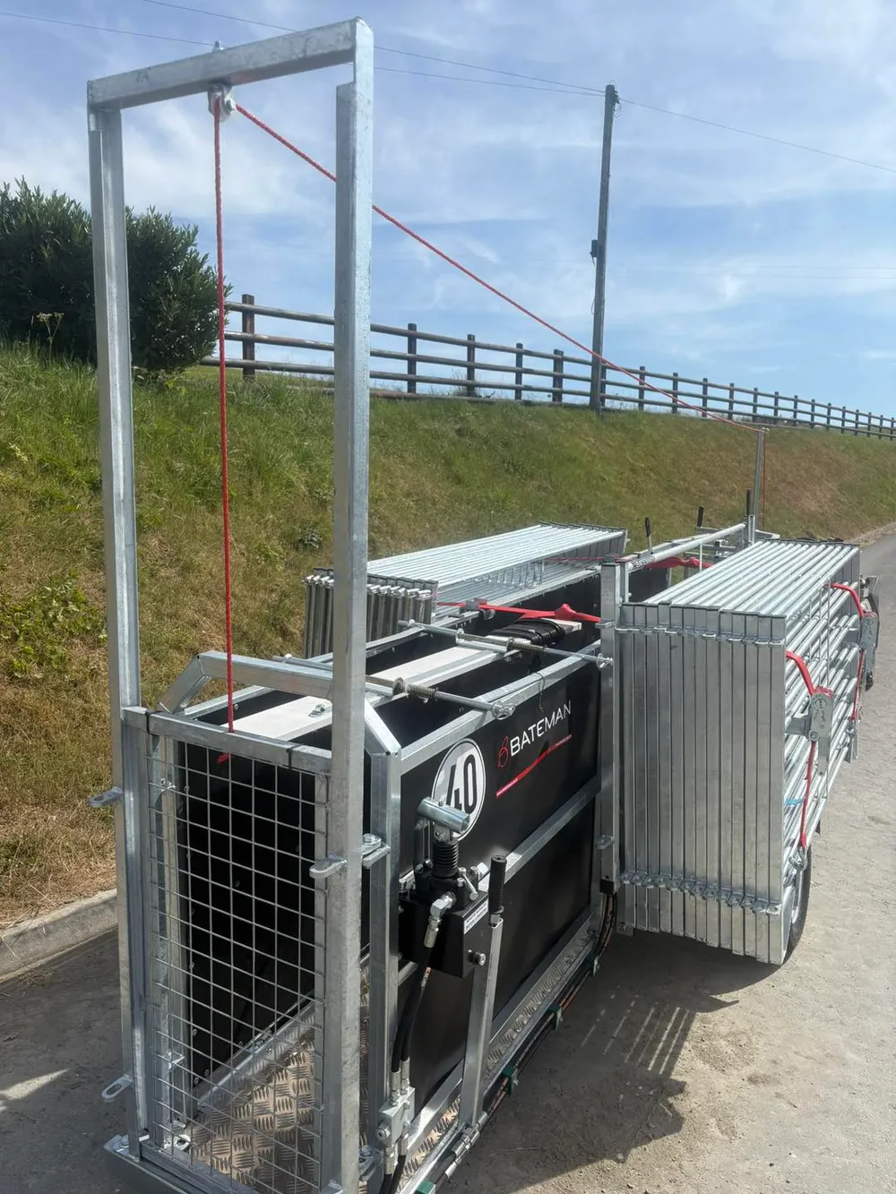 The front of the Bateman trailer showing the mesh gate, hydraulic hand pump and stacked hurdles
