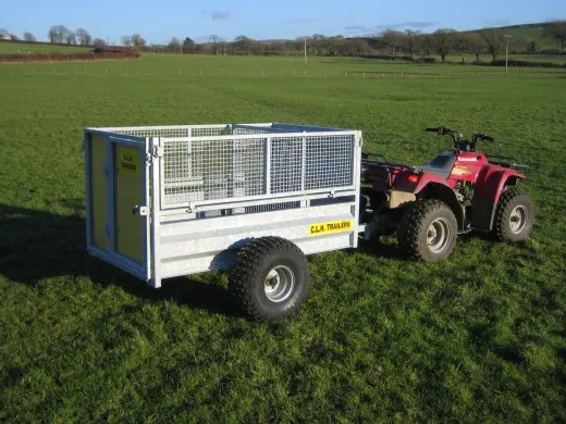 A galvanised CLH mesh-sided ATV livestock trailer behind a quad