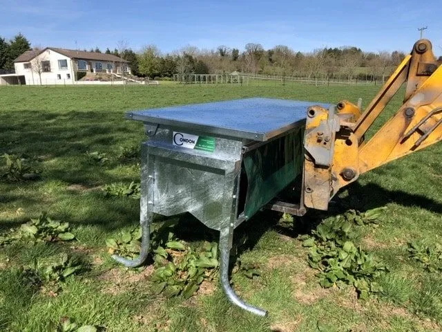 The feeder being lifted by a loader - it moves between fields in one piece
