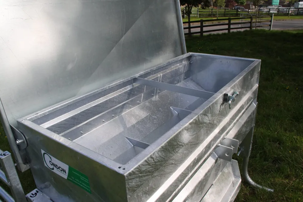 The lid raised, showing the divided galvanised trough inside