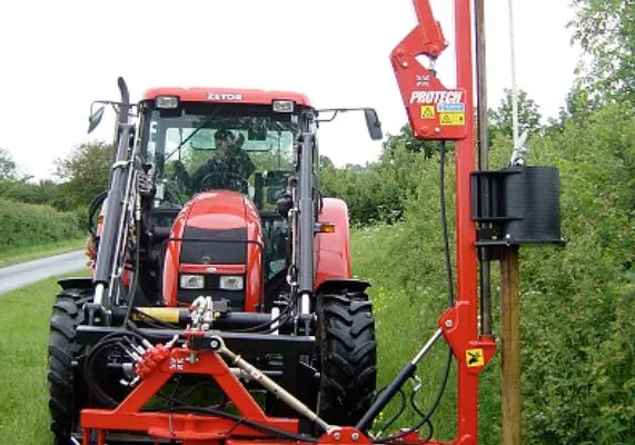 A Protech P180 post knocker mounted on the rear of a tractor, driving a fence post