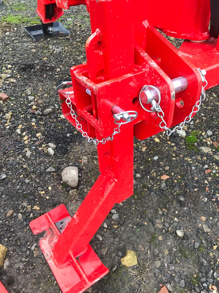 The three-point linkage hitch, with its pins and retaining chains