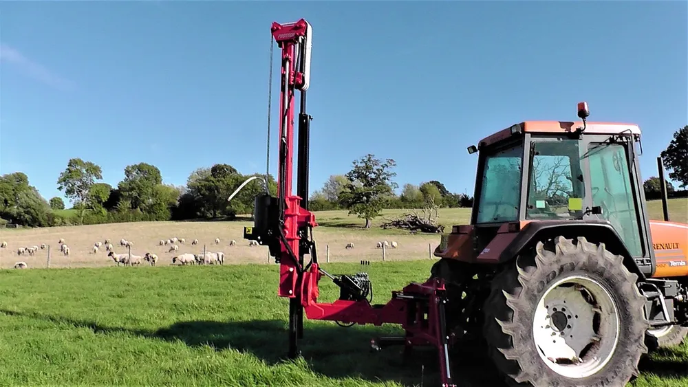 The P230S working in a field, with sheep grazing behind