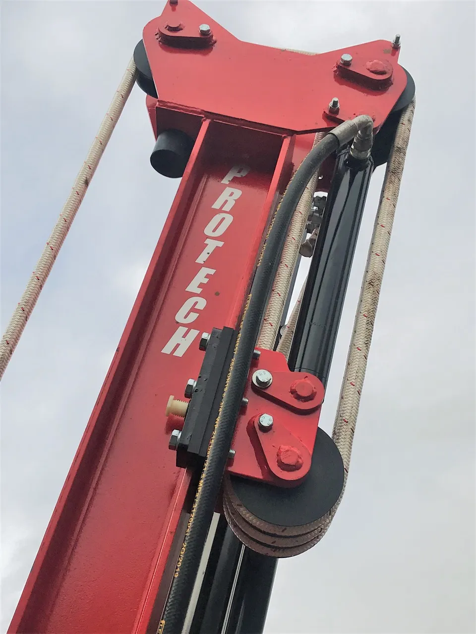 Looking up the mast at the ropes and pulleys that lift the weight