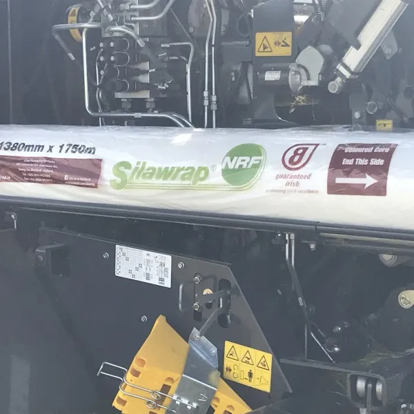 A roll of Silawrap NRF film loaded in a baler, labelled 1380mm x 1750m