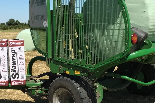 A McHale wrapper wrapping a bale in green Silawrap silage film